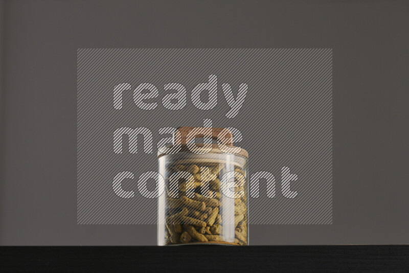 Turmeric in a glass jar on black background