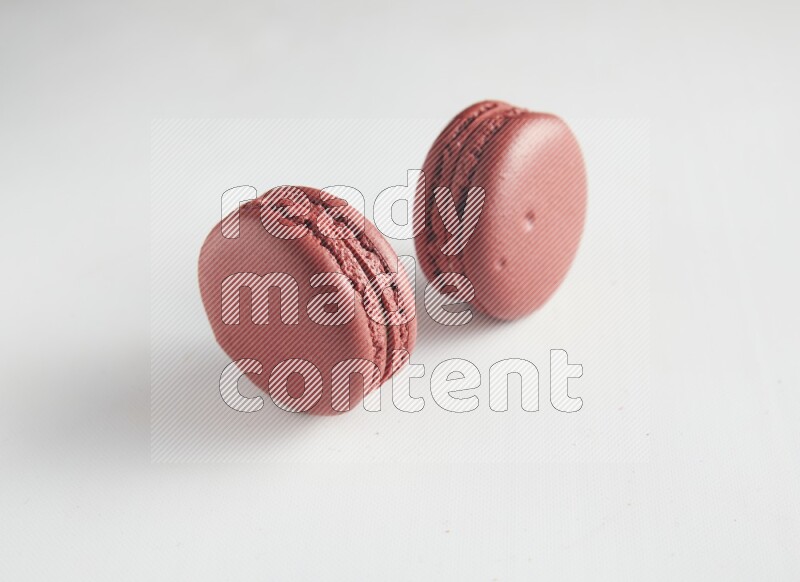 45º Shot of two Red Velvet macarons on white background