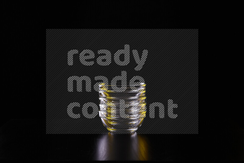 Glassware with rim light in yellow and white against black background