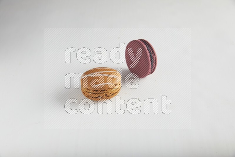 45º Shot of of two assorted Brown Irish Cream, and Red Cherry macarons on white background