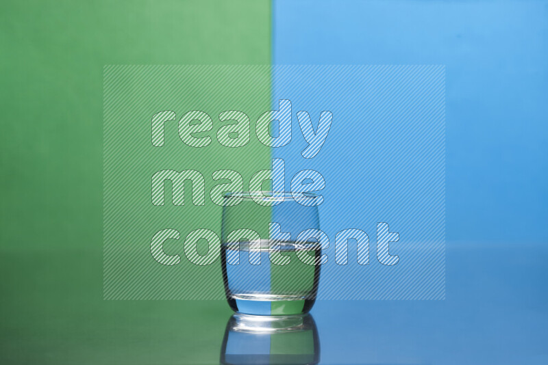 The image features a clear glassware filled with water, set against green and blue background