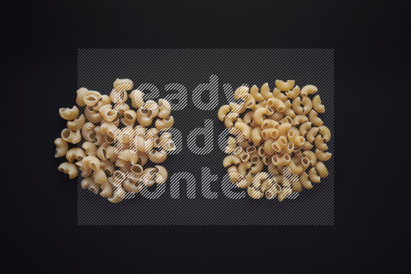 Different pasta types in bunches on black background