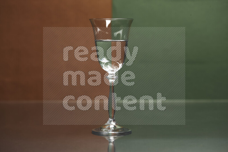 The image features a clear glassware filled with water, set against brown and dark green background