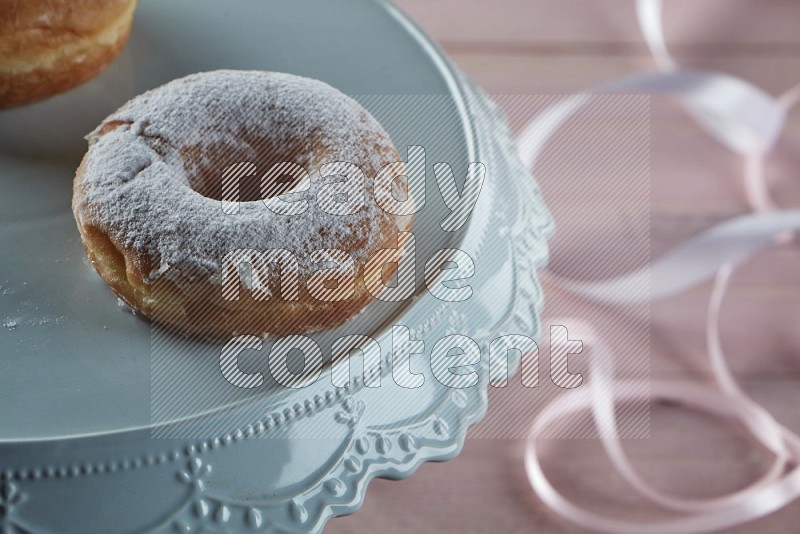 Sugar dusted doughnut on pink wooden background