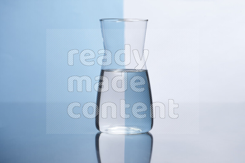 The image features a clear glassware filled with water, set against white and light blue background