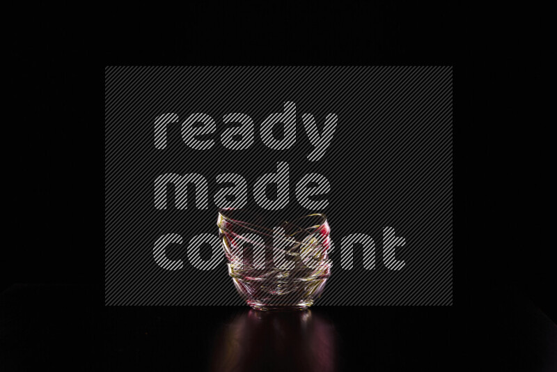 Glassware with rim light in red and yellow against black background