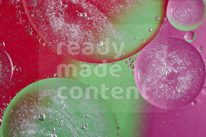Close-ups of abstract oil bubbles on water surface in shades of pink, green and red
