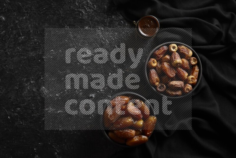 تمر في أوعية فخارية مع القهوة علي خلفية سوداء خشبية