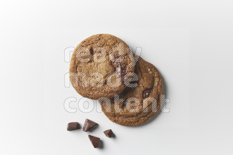 Chocolate chips cookies with chocolate beside it on a white background