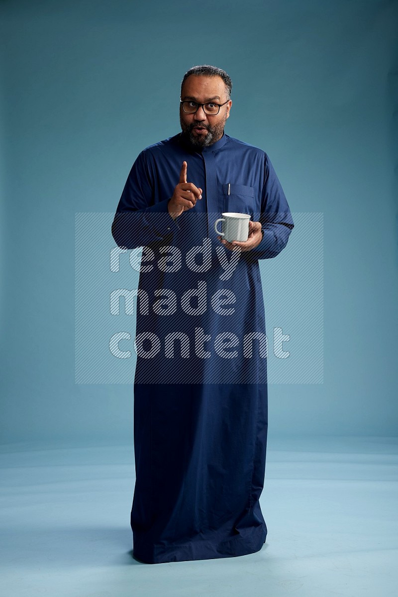 Saudi Man without shimag Standing drinking coffee on blue background