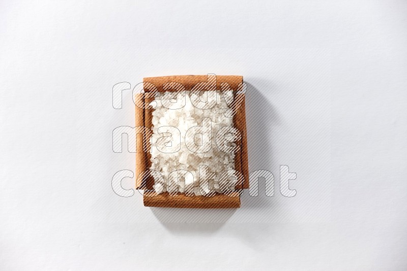 A single square of cinnamon sticks full of salt on white flooring