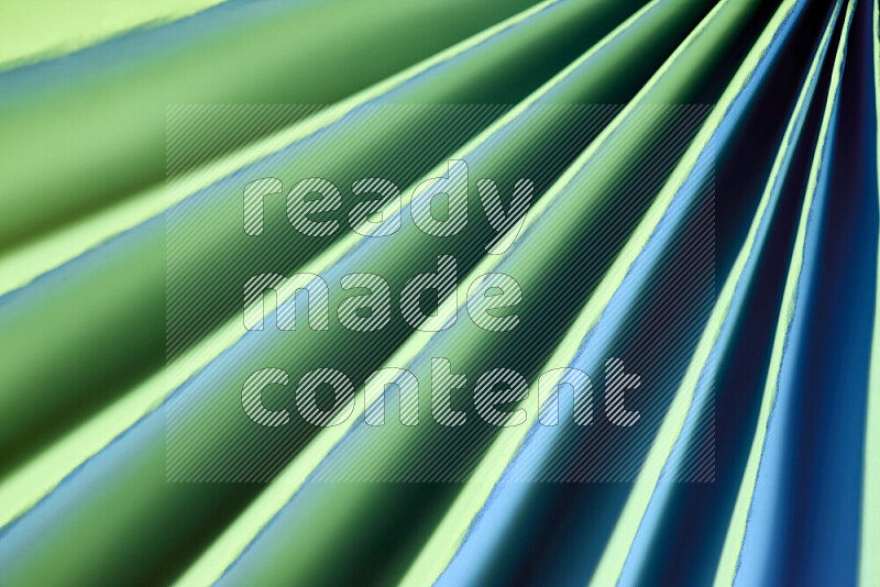 An image presenting an abstract paper pattern of lines in green and blue tones