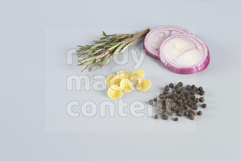 Raw pasta with different ingredients such as cherry tomatoes, garlic, onions, red chilis, black pepper, white pepper, bay laurel leaves, rosemary, cardamom and mushrooms on light blue background