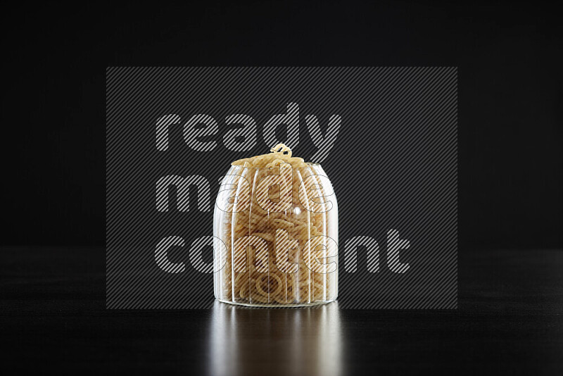 Snacks in a glass jar on black background