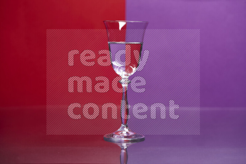 The image features a clear glassware filled with water, set against red and purple background