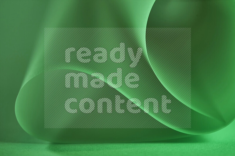 An abstract art piece displaying smooth curves in green gradients created by colored light