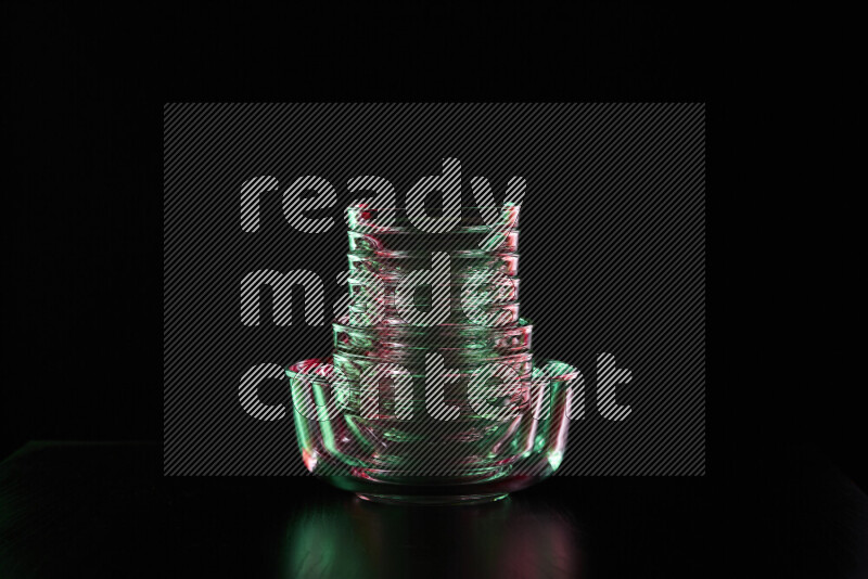 Glassware with rim light in red and green against black background