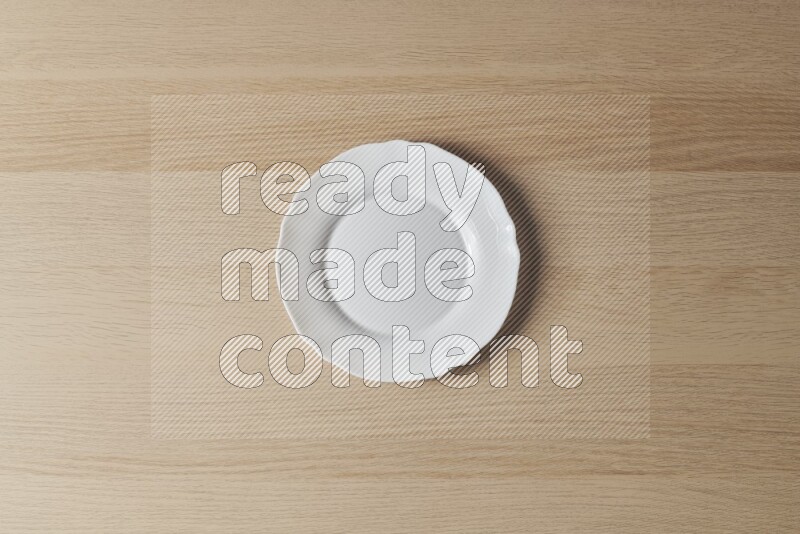 A white ceramic circular plate on light wooden background