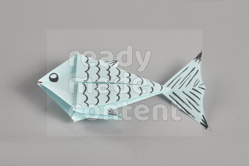 Origami fish on grey background