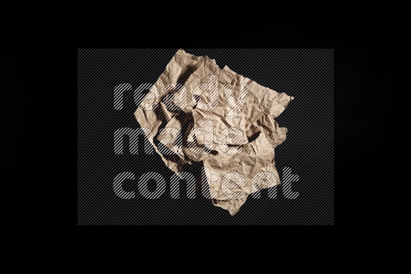 Crumpled craft paper on black background