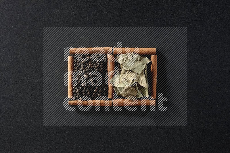2 squares of cinnamon sticks full of black peppers and bay laurel leaves on black flooring
