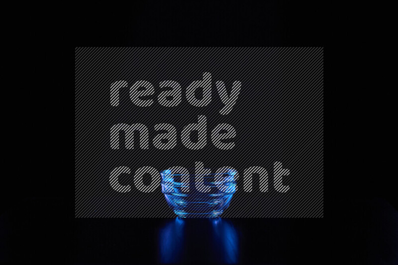 Glassware with rim light in blue against black background