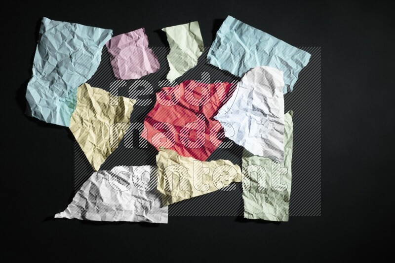 Crumpled multicolored paper on black background