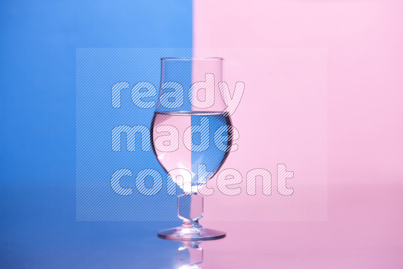 The image features a clear glassware filled with water, set against blue and rose background