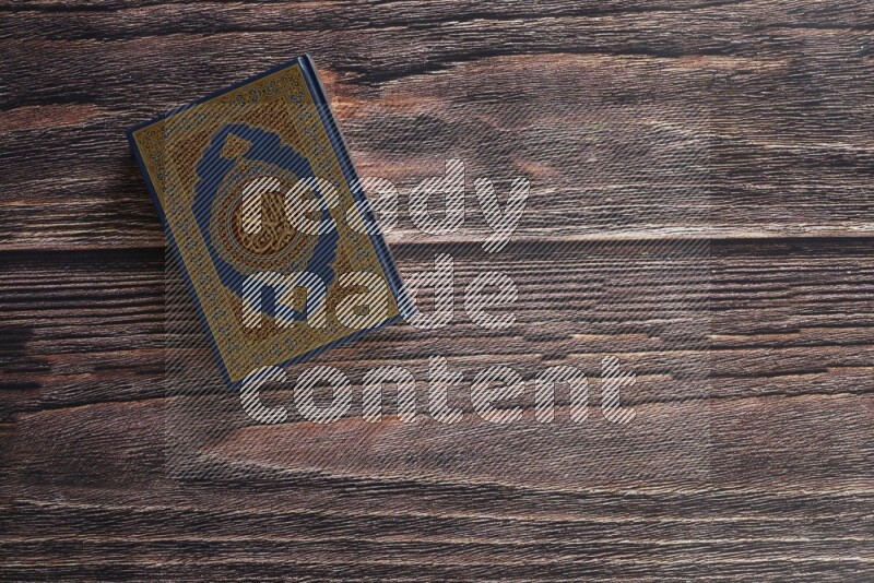 مصحف مع سبحة صلاه علي خلفية خشبية