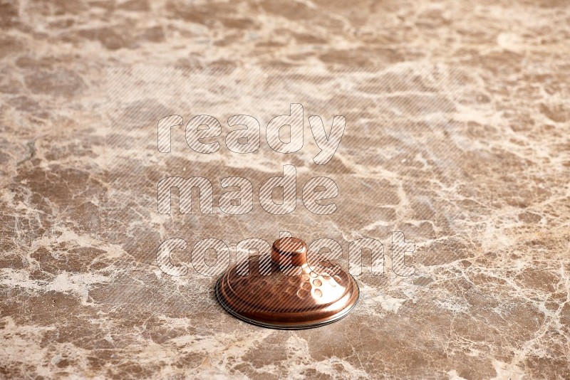 Small Copper Pot's Lid on Beige Marble Flooring