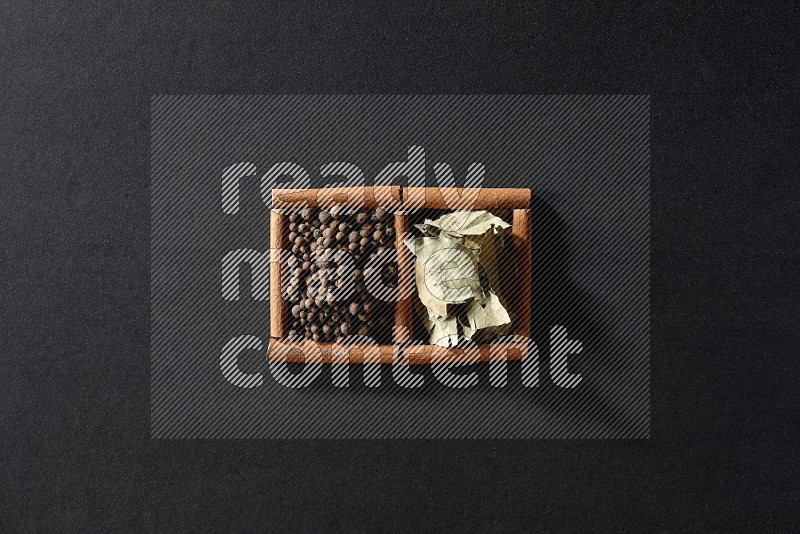 2 squares of cinnamon sticks full of allspice and bay laurel leaves on black flooring