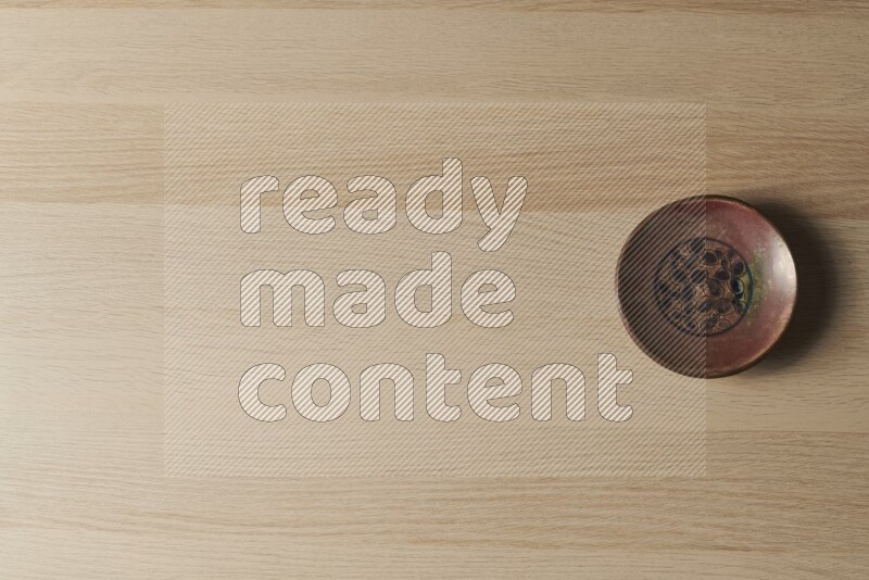 صحن فخاري مزخرف على خلفية خشبية فاتحة