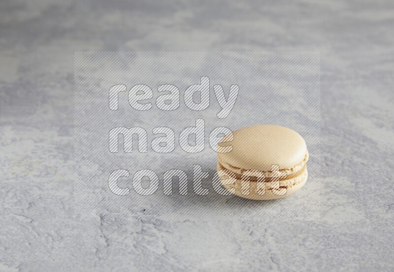 45º Shot of white marbleCaramel fleur de sel macaron on white  marble background