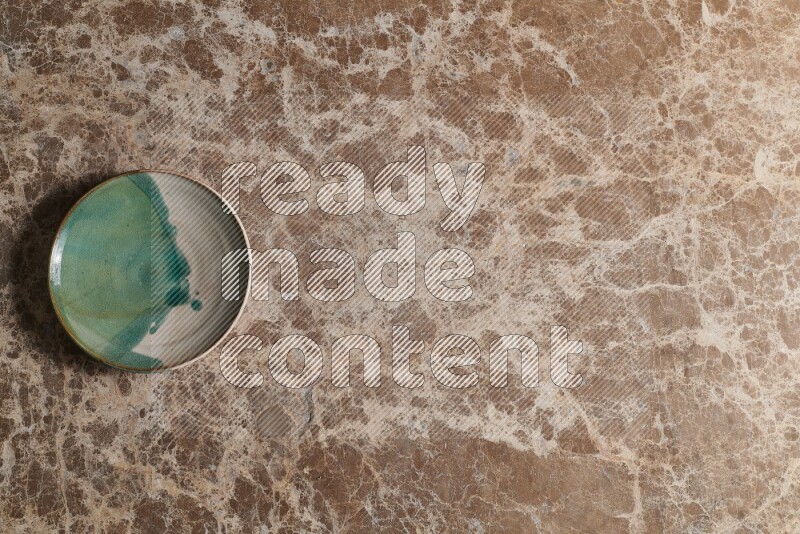 A decorative pottery plate on beige marble background