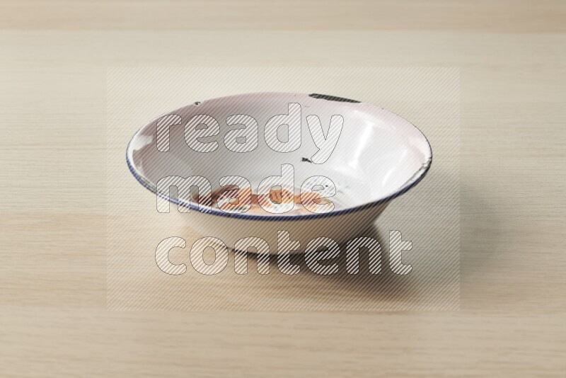 صحن معدني عتيق على خلفية خشبية فاتحة