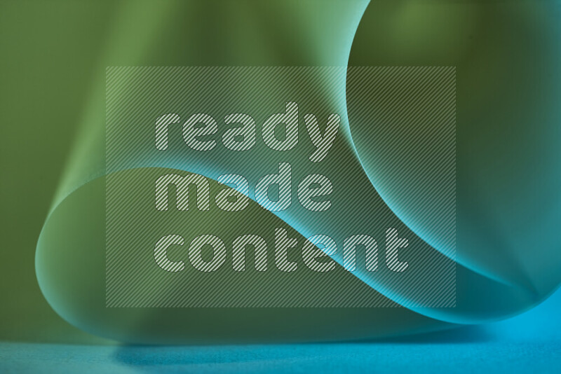 An abstract art piece displaying smooth curves in green and blue gradients created by colored light