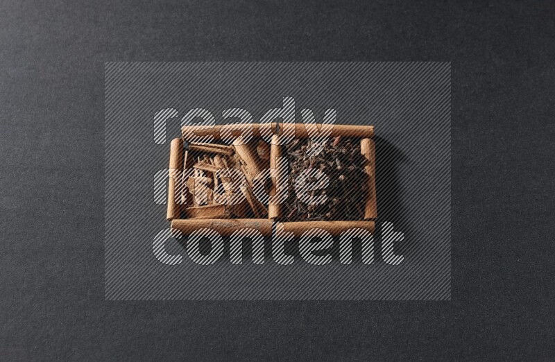 2 squares of cinnamon sticks full of cloves and cinnamon on black flooring