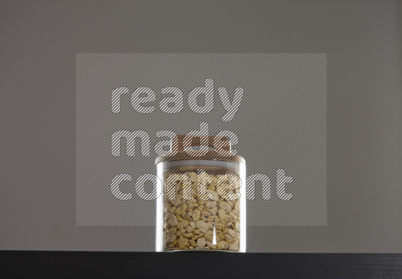 Crushed beans in a glass jar on black background