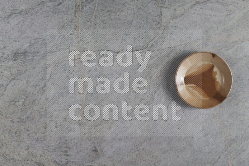 صحن فخاري متعدد الألوان على خلفية من الرخام الرمادي