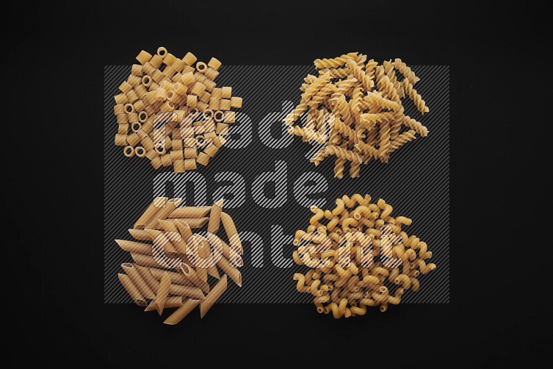 Different pasta types in bunches on black background