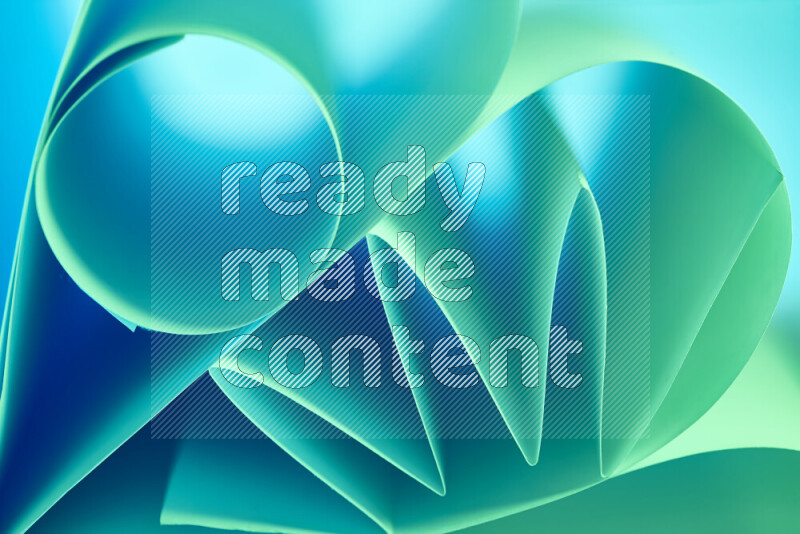 عرض فني لطيات الورق تخلق مزيج من الأشكال الهندسية، مضاءة بإضاءة ناعمة بدرجات اللون الأخضر والأزرق