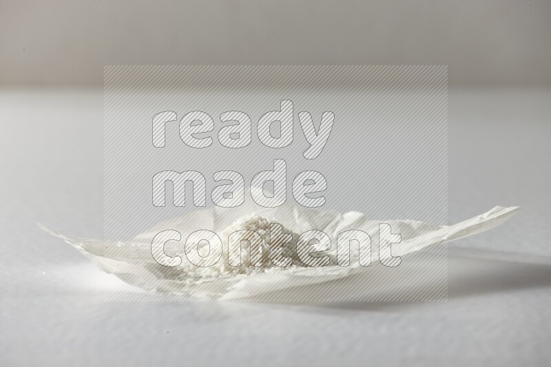 Desiccated coconut on a piece of paper on a white background in different angles