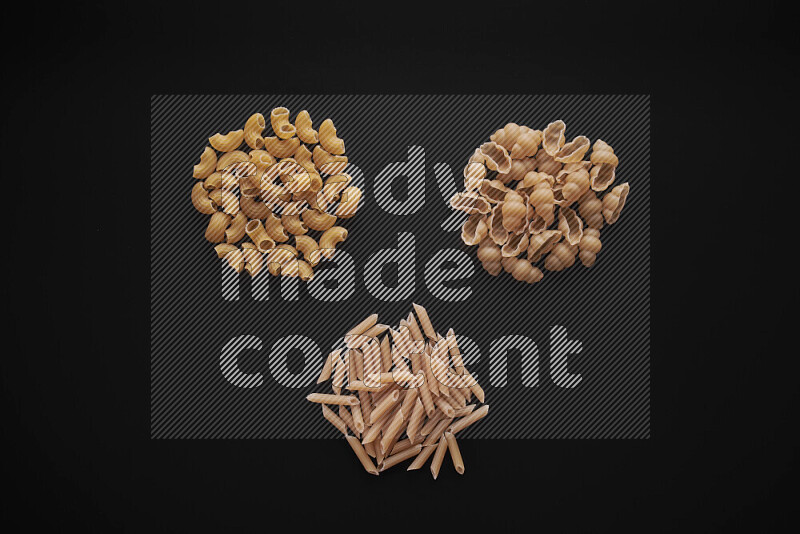 Different pasta types in bunches on black background