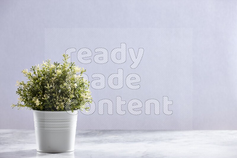 Artificial plant in white pot on grey marble background