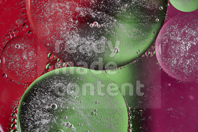 لقطات مقربة لفقاعات من الزيت على سطح الماء باللون الوردي والأخضر والأحمر