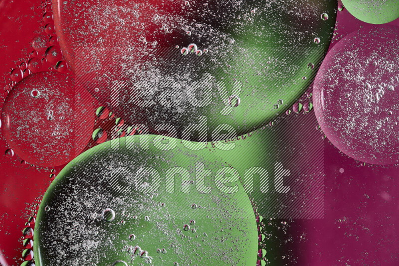 Close-ups of abstract oil bubbles on water surface in shades of pink, green and red