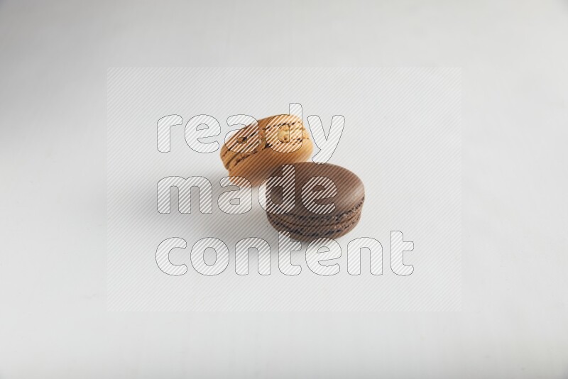 45º Shot of of two assorted Brown Irish Cream, and Brown Dark Chocolate macarons on white background