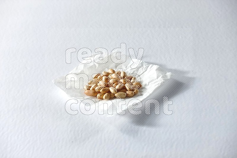 Peeled peanuts on a crumpled piece of paper on a white background in different angles