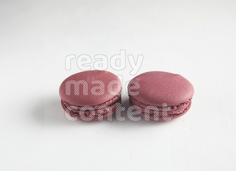 45º Shot of two Red Cherry macarons on white background