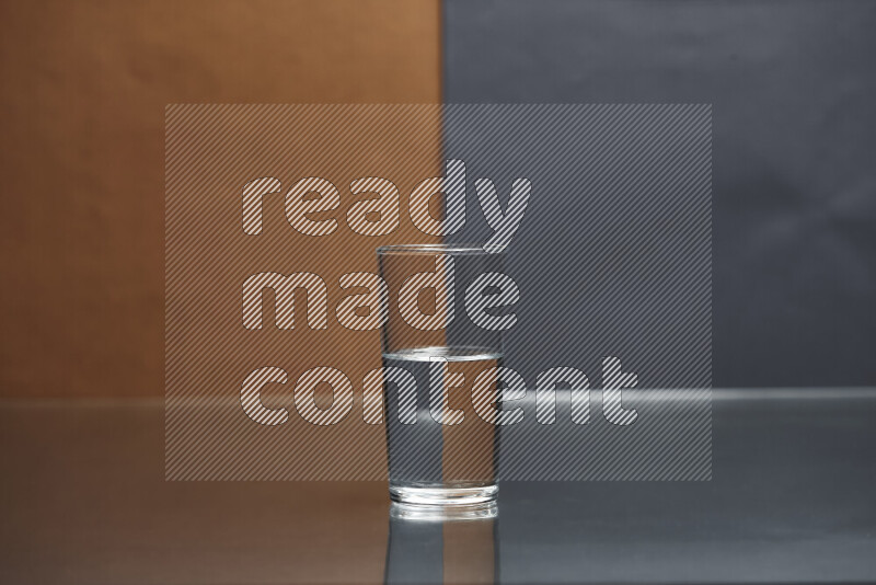 The image features a clear glassware filled with water, set against brown and dark blue background